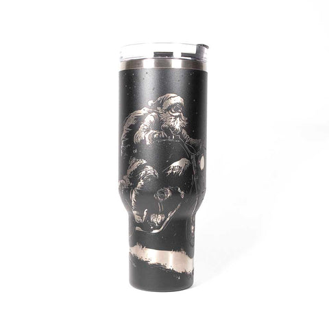 Black 40 ounce travel mug with an laser engraving of Santa taking off into the night on his trusty motorcycle. side 1
