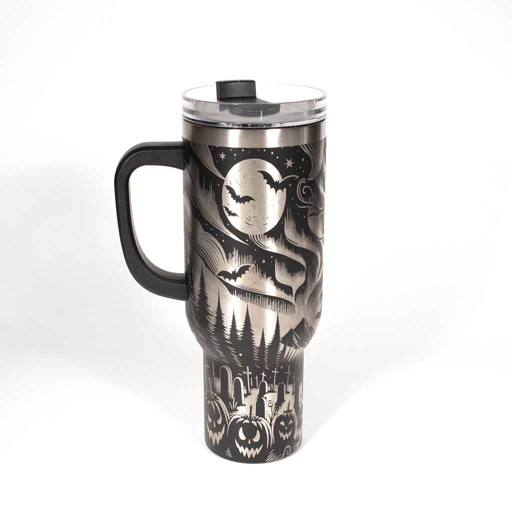 This is a black 40 ounce tumbler with a screw on lid with a drinking hole access and a straw. The laser engraving is of the northern lights, full moon with bats flying, gravestones and ghoulish pumpkins near a tree . Side 1