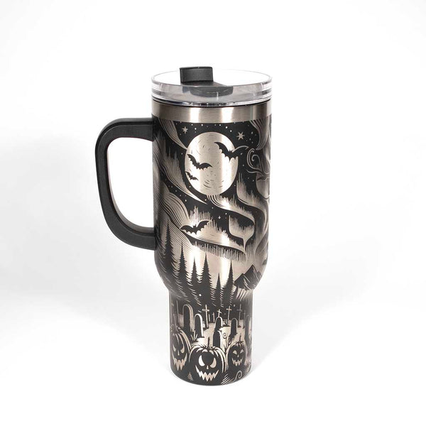This is a black 40 ounce tumbler with a screw on lid with a drinking hole access and a straw. The laser engraving is of the northern lights, full moon with bats flying, gravestones and ghoulish pumpkins near a tree . Side 1
