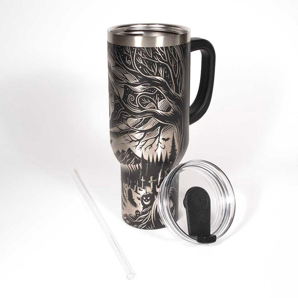 This is a black 40 ounce tumbler with a screw on lid with a drinking hole access and a straw. The laser engraving is of the northern lights, full moon with bats flying, gravestones and ghoulish pumpkins near a tree . Shown with lid removed and straw.
