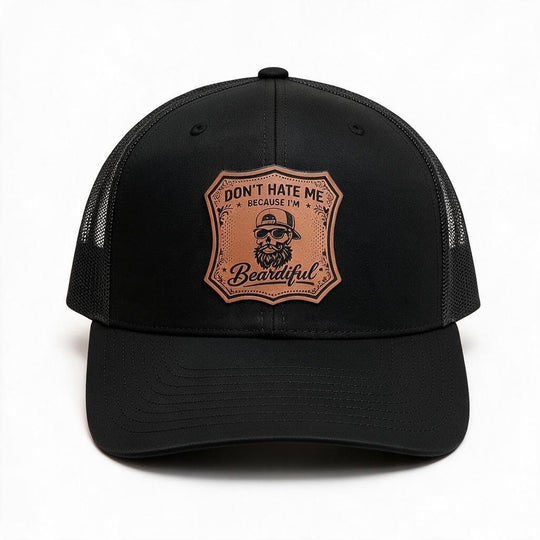 A black trucker-style cap with a brown shield-shaped engraved patch on the front that reads &
