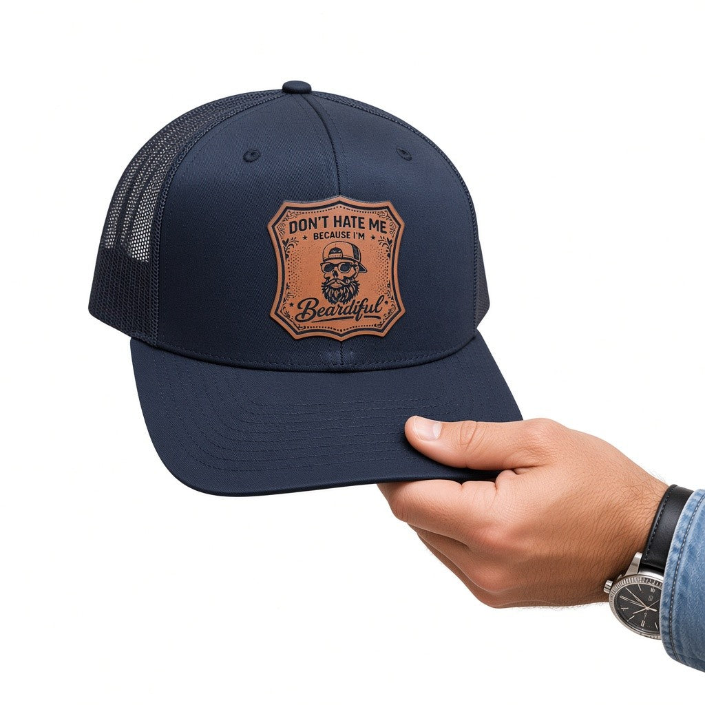 A navy blue trucker hat with a brown engraved patch on the front that reads &