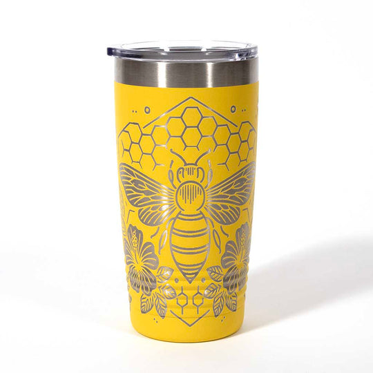 Yellow powder coated 20 ounce stainless steel tumbler. Engraved with flowers, a honeycomb and a bee with the words "Bee Happy". Side 2