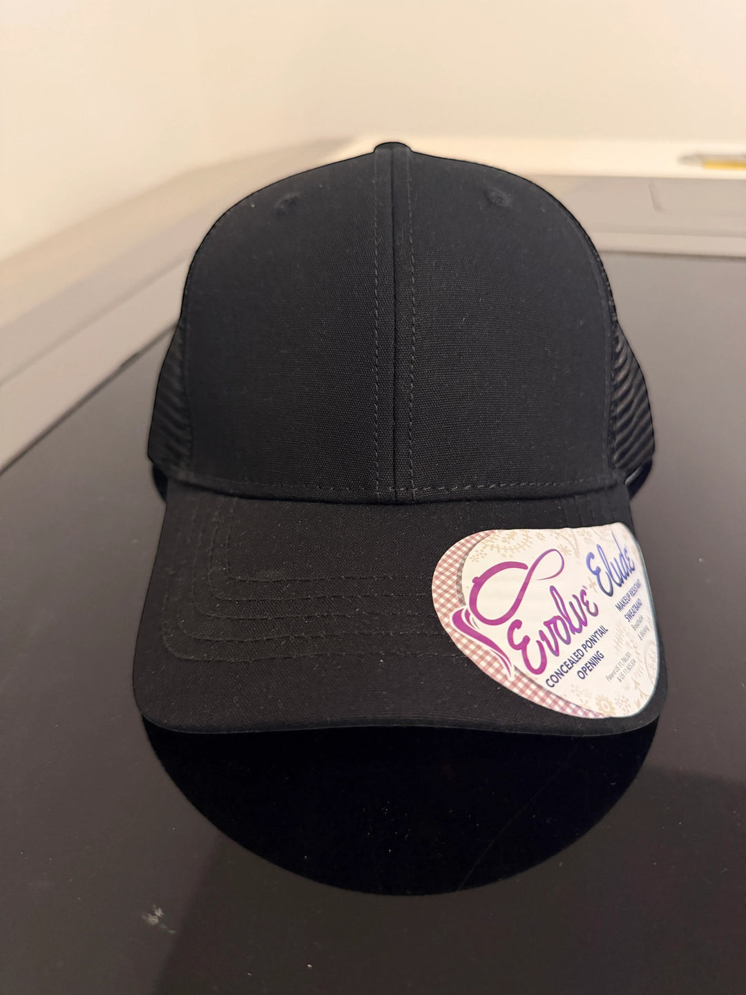 Dailey Woodworking black ponytail trucker hat with a breathable mesh back and a pre-curved visor.