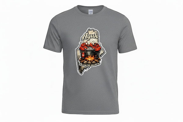 Gravel colored t-shirt with a graphic of the state of Maine containing a lobster pot over a fire with lobsters sitting inside and the words "Ayuh" and "The way life should be"