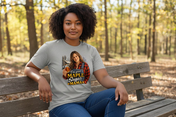 Dailey Woodworking grey short sleeve t-shirt with a graphic of a woman holding a maple leaf and bottle of syrup, with text "I'm Your Maple Sugar Mama".