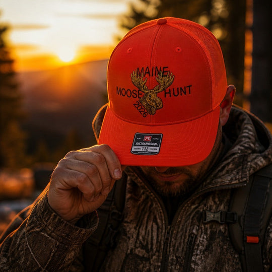 Dailey Woodworking orange Richardson 112 trucker hat with Maine Moose Hunt 2026 embroidery worn at sunset