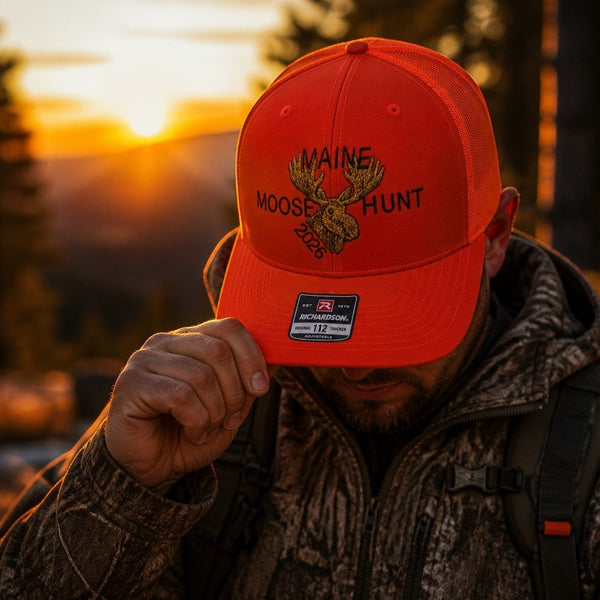 Dailey Woodworking orange Richardson 112 trucker hat with Maine Moose Hunt 2026 embroidery worn at sunset