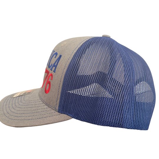 Dailey Woodworking patriotic trucker hat with gray front, royal blue mesh back, and America 250 embroidery.
