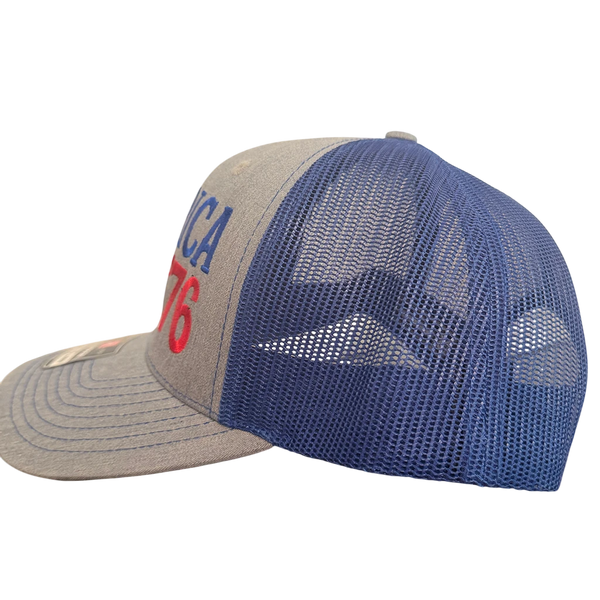 Dailey Woodworking patriotic trucker hat with gray front, royal blue mesh back, and America 250 embroidery.