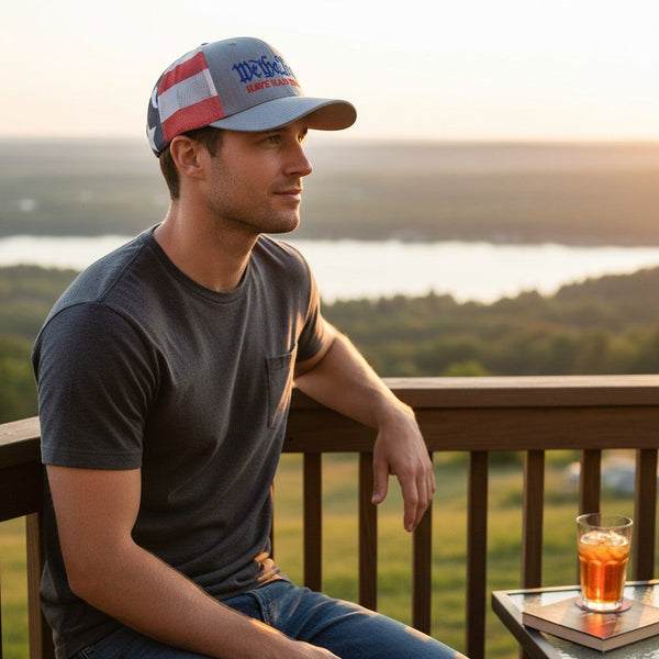 Dailey Woodworking trucker hat with We The People embroidery, heather grey front, and stars-and-stripes mesh back