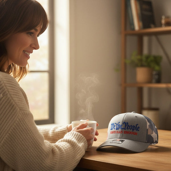 Dailey Woodworking Richardson 112 trucker hat with We The People embroidery on a wooden table next to a woman