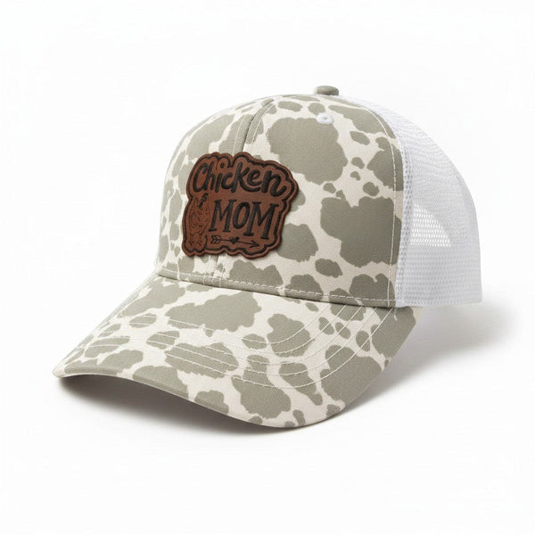 Dailey Woodworking grey cow print trucker hat with white mesh back and "Chicken Mom" leatherette patch.
