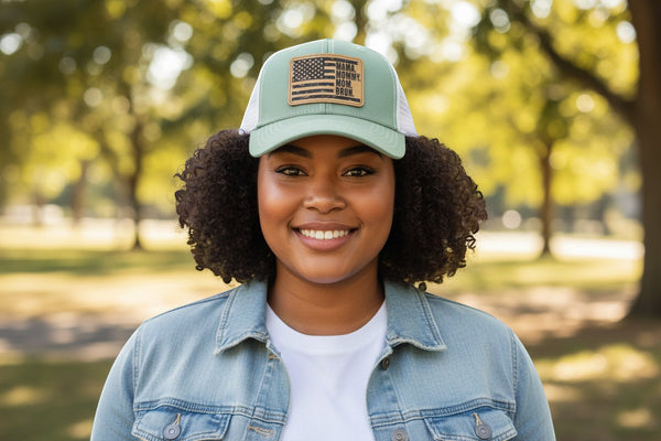 Dailey Woodworking seafoam and white mesh trucker hat with leatherette patch featuring distressed American flag and "Mama. Mommy. Mom. Bruh." text.