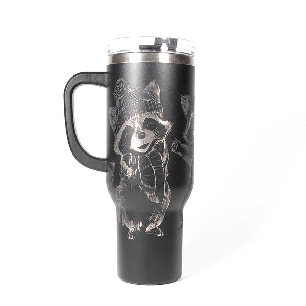 40 ounce black travel mug with three engraved raccoons dressed in scarves and hats. Side 2