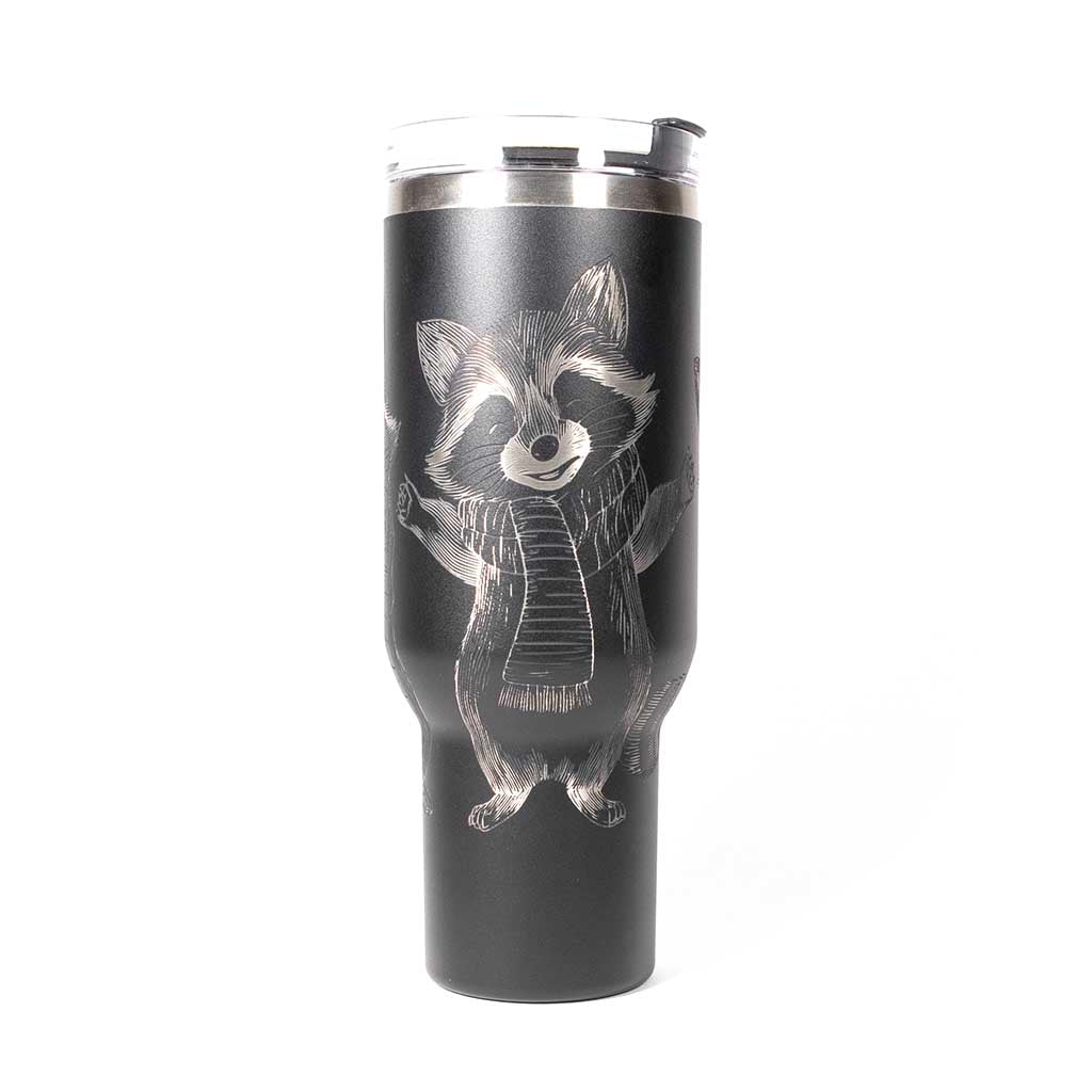40 ounce black travel mug with three engraved raccoons dressed in scarves and hats. Side 1
