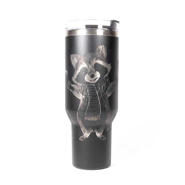 40 ounce black travel mug with three engraved raccoons dressed in scarves and hats. Side 1