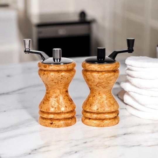 Set of Ferris mini-grinders made in Maple Burl sitting on a white marble counter with blurred kitchen background - Dailey Woodworking