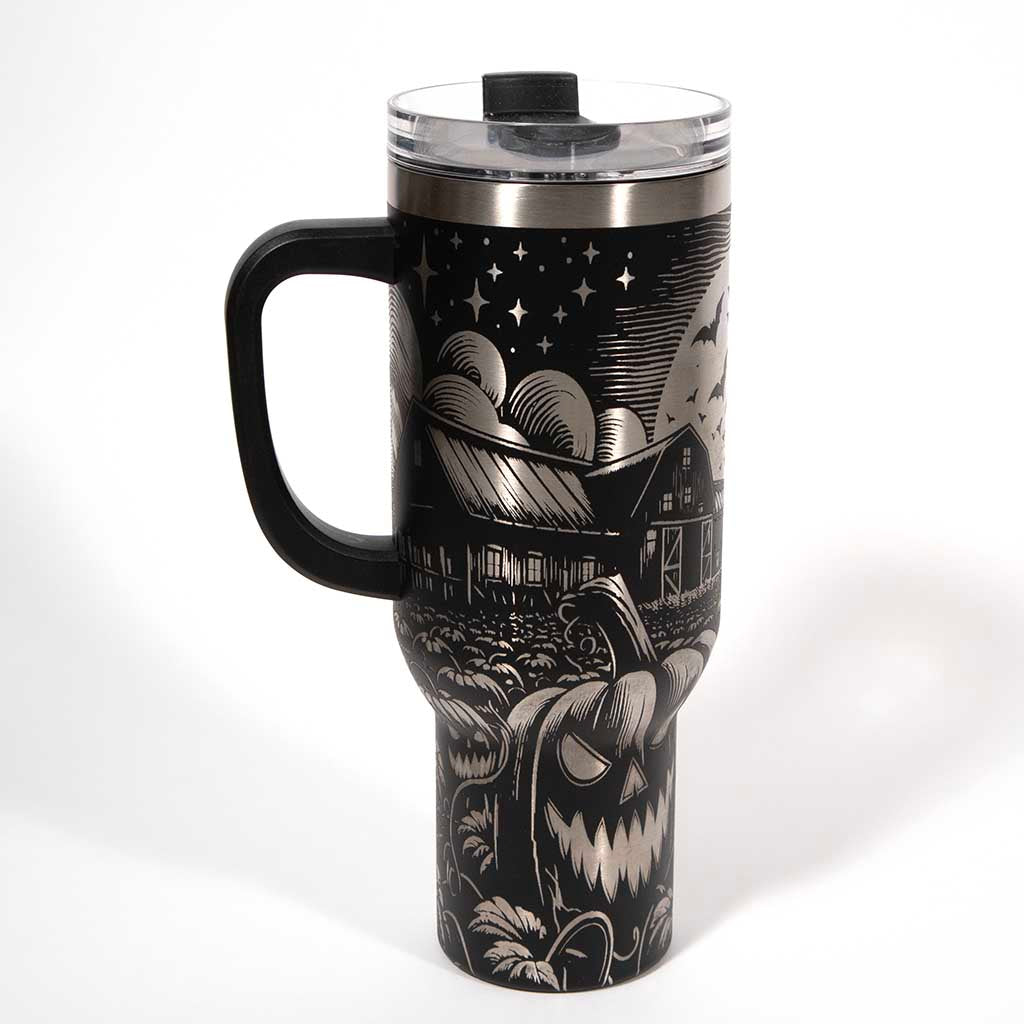 This is a black 40 ounce tumbler with a screw on lid with a drinking hole access and a straw. The laser engraving is of a pumpkin patch, a barn and scarecrow. Side 1