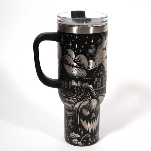 This is a black 40 ounce tumbler with a screw on lid with a drinking hole access and a straw. The laser engraving is of a pumpkin patch, a barn and scarecrow. Side 1