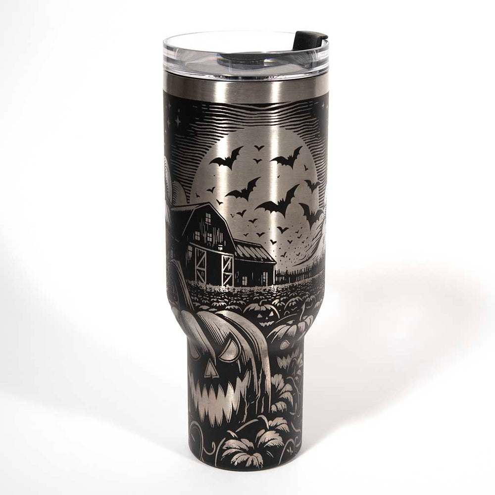 This is a black 40 ounce tumbler with a screw on lid with a drinking hole access and a straw. The laser engraving is of a pumpkin patch, a barn and scarecrow. Side 2