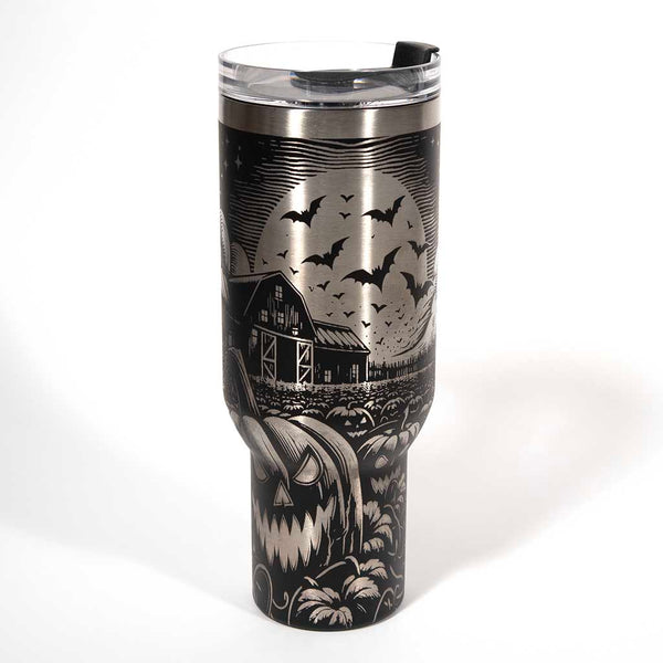 This is a black 40 ounce tumbler with a screw on lid with a drinking hole access and a straw. The laser engraving is of a pumpkin patch, a barn and scarecrow. Side 2