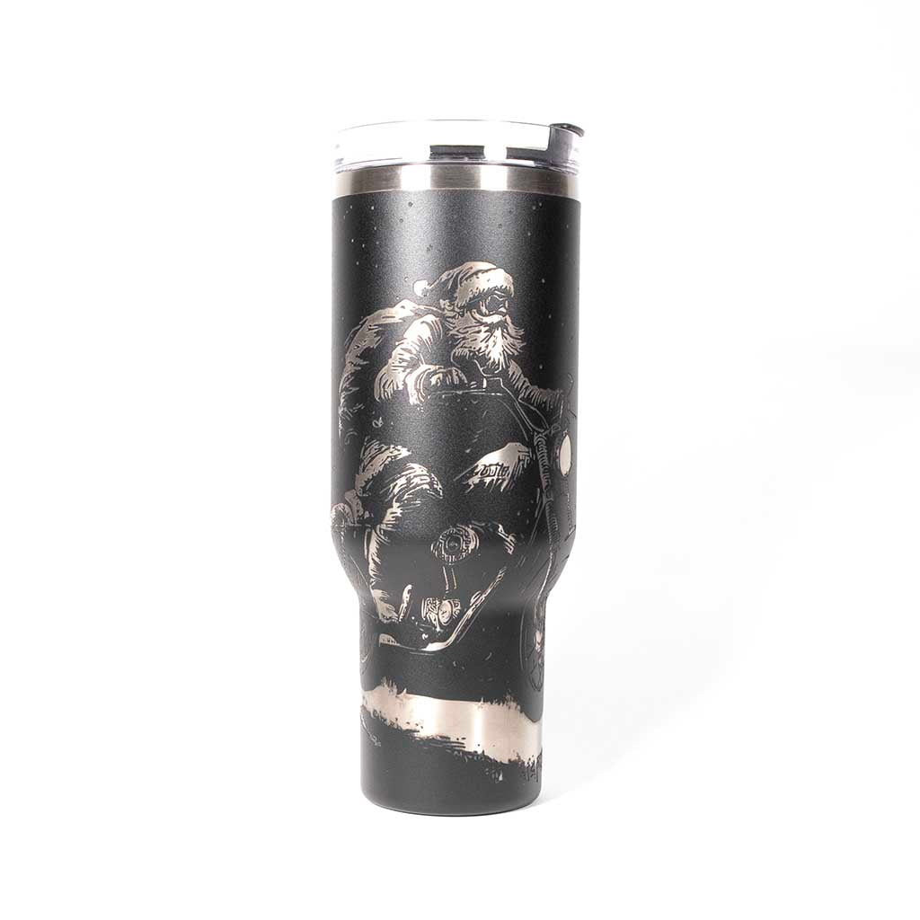 Black 40 ounce travel mug with an laser engraving of Santa taking off into the night on his trusty motorcycle. side 1