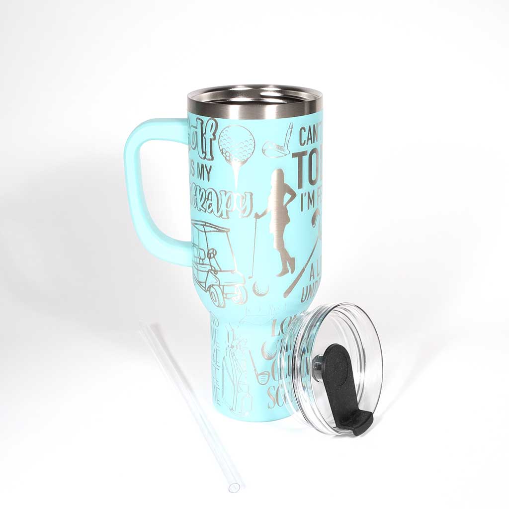 Seafoam 40 ounce travel mug with funny golf sayings and images of a female golfer. Shown with straw and cover off. 