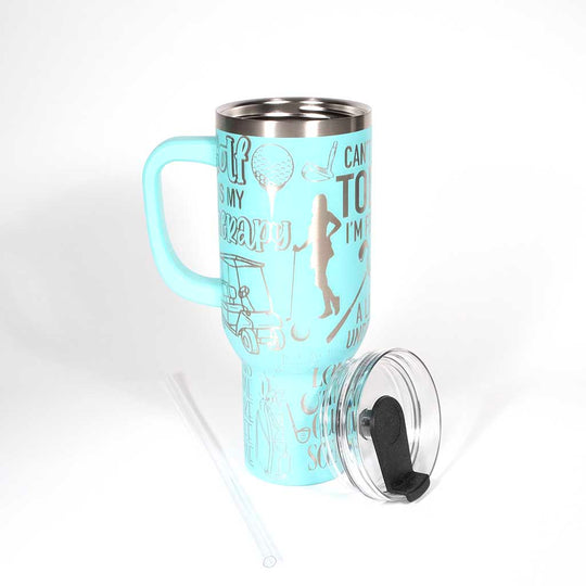 Seafoam 40 ounce travel mug with funny golf sayings and images of a female golfer. Shown with straw and cover off. 